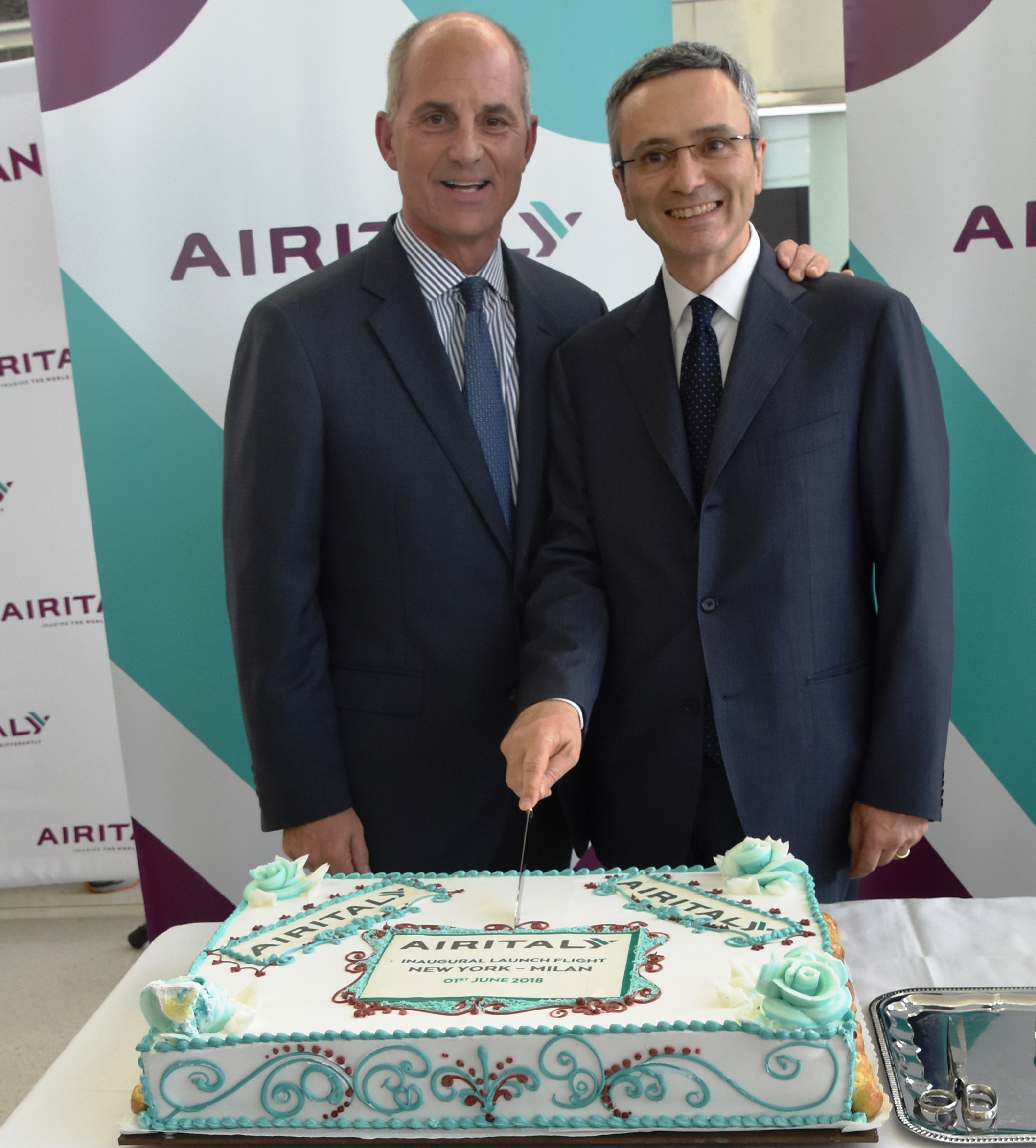 John Selden (left), of the NY and NJ Port Authority, and Marco Rigotti (right), Deputy Executive Chairman of Air Italy, cut a cake to celebrate Air Italy's first flight from JFK Int'l Airport. Photo courtesy of: Air Italy Media Center.